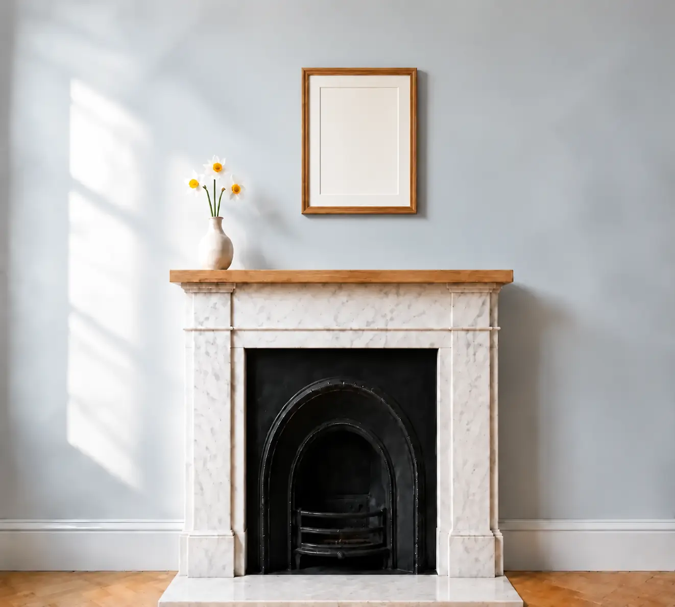 Quiet blue-grey room with an oak frame, daffodils and a marble fireplace